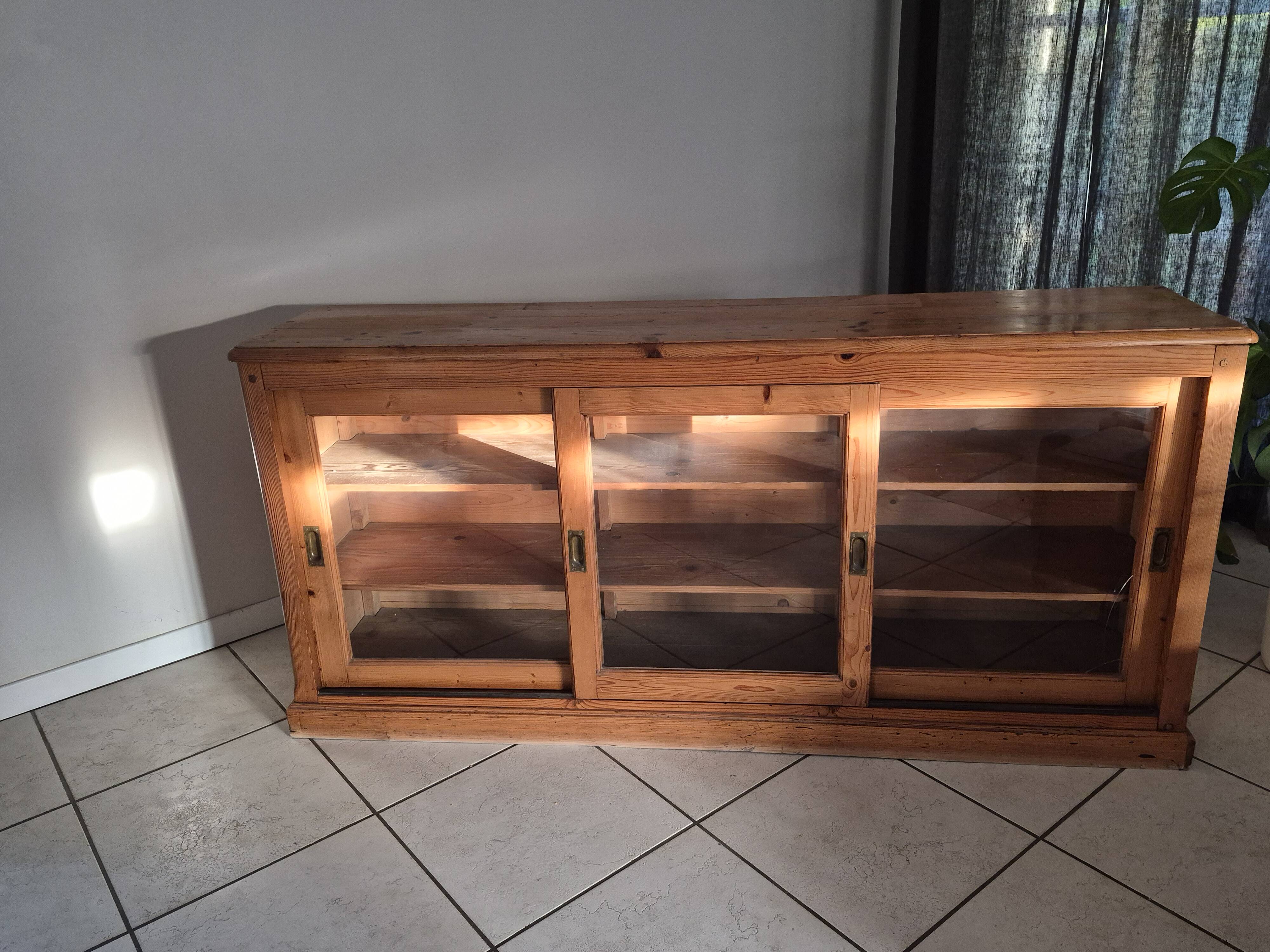 Antique wooden sideboard with three sliding glass doors.