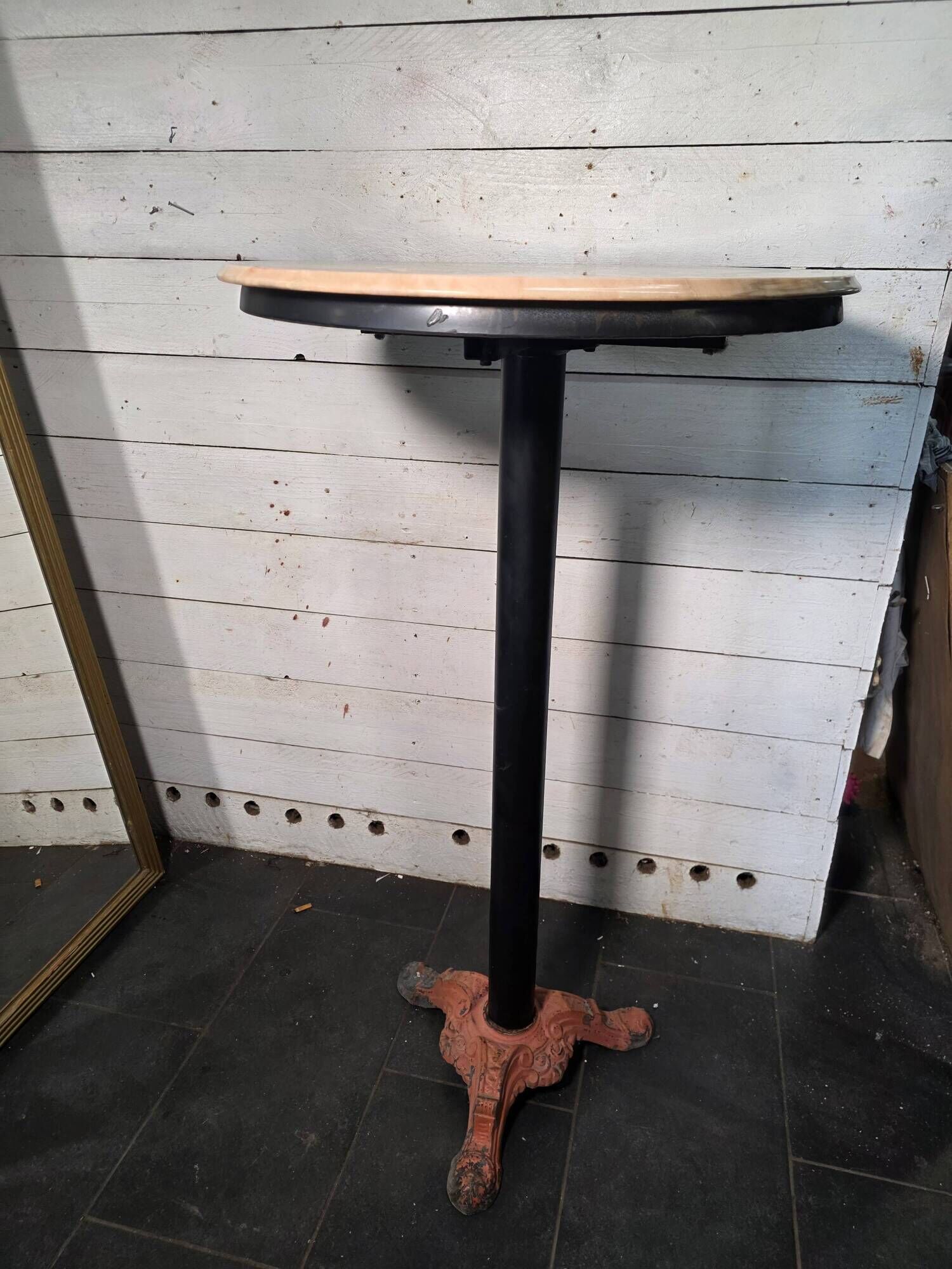 Bistro standing table with marble top and cast iron base.