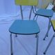 Two chairs and a yellow and blue stool in formica
