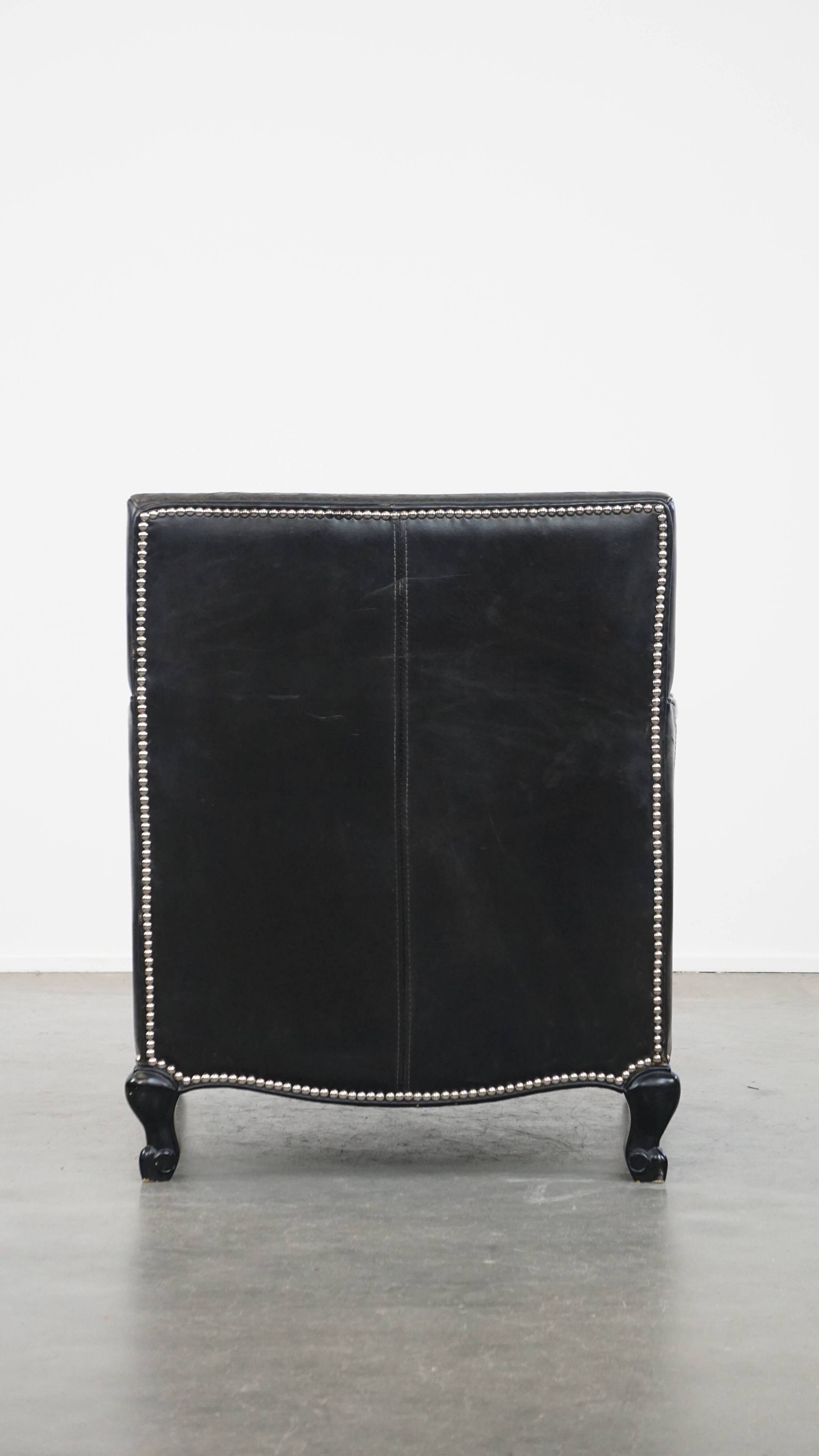 Armchair in black grained cowhide leather with a deep seat