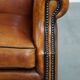 Sheepskin wingback armchair with stitching and black piping