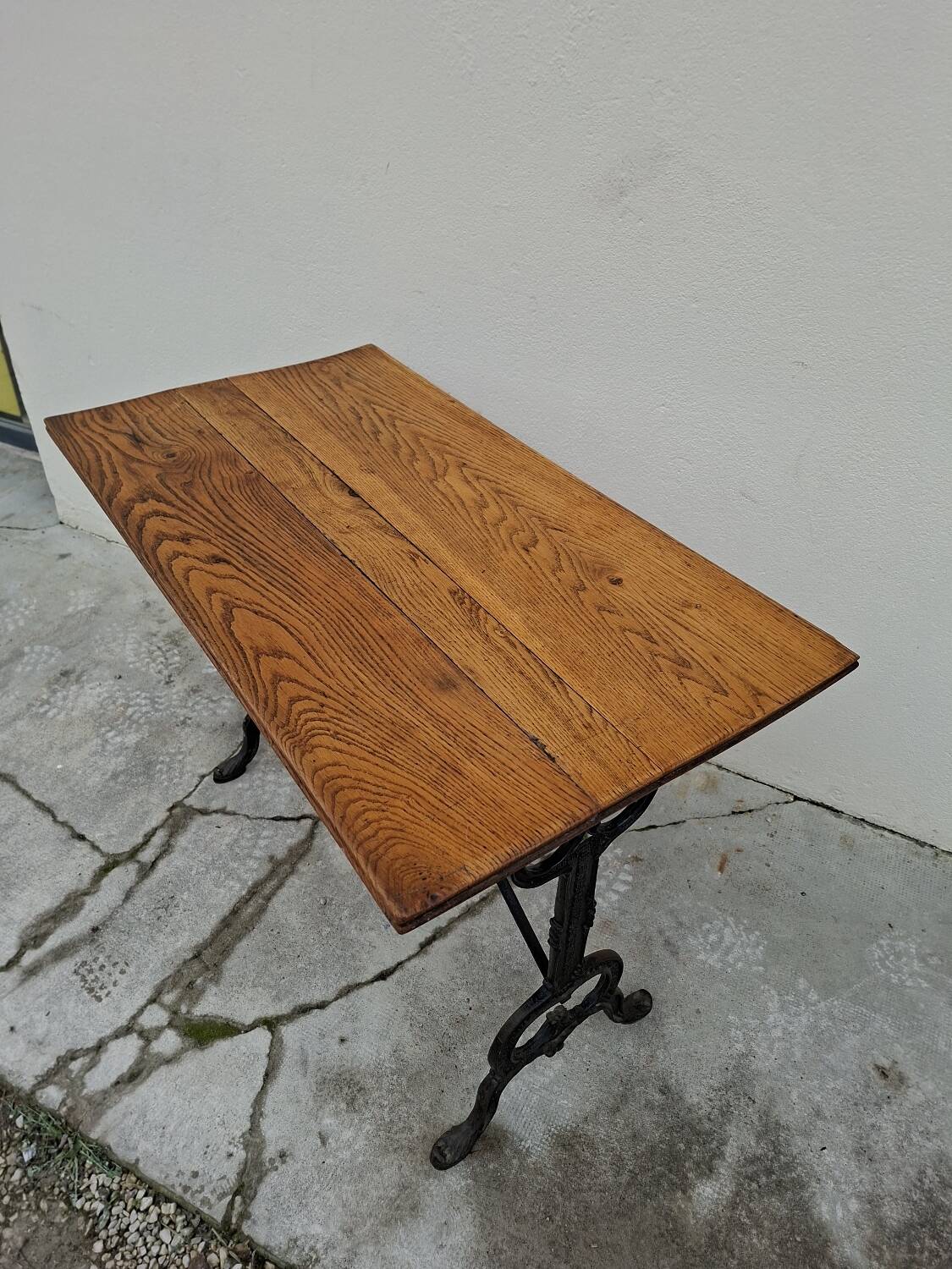 Solid oak bistro table with a cast iron base, signed.