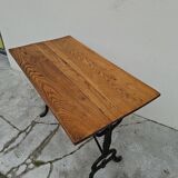 Solid oak bistro table with a cast iron base, signed.