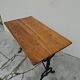 Solid oak bistro table with a cast iron base, signed.