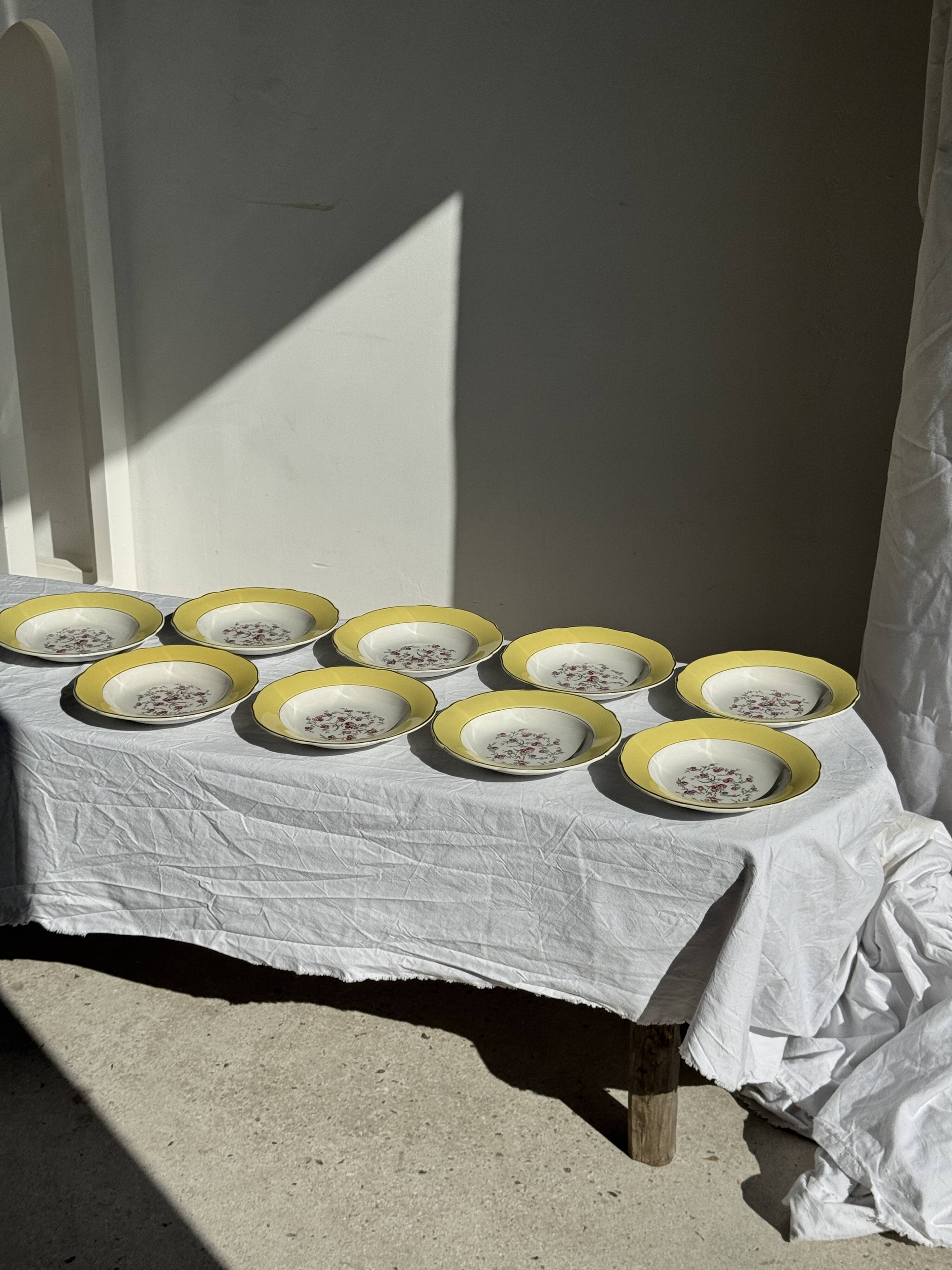 Set of 9 large vintage yellow deep plates with pink flowers and a gold rim.