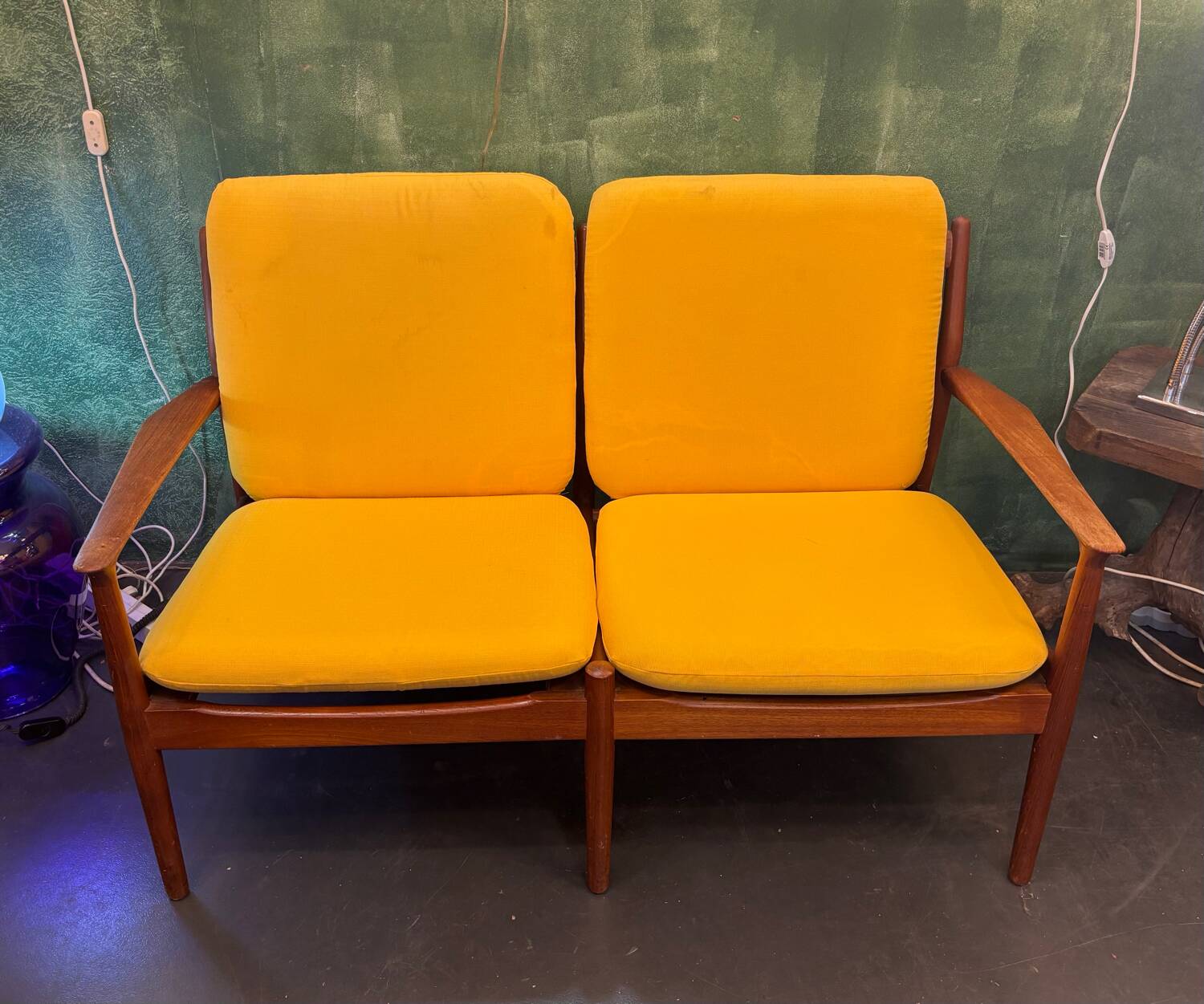 Vintage Scandinavian two-seater bench with mustard yellow cushions.