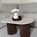 Oval coffee table in travertine and fluted wood.