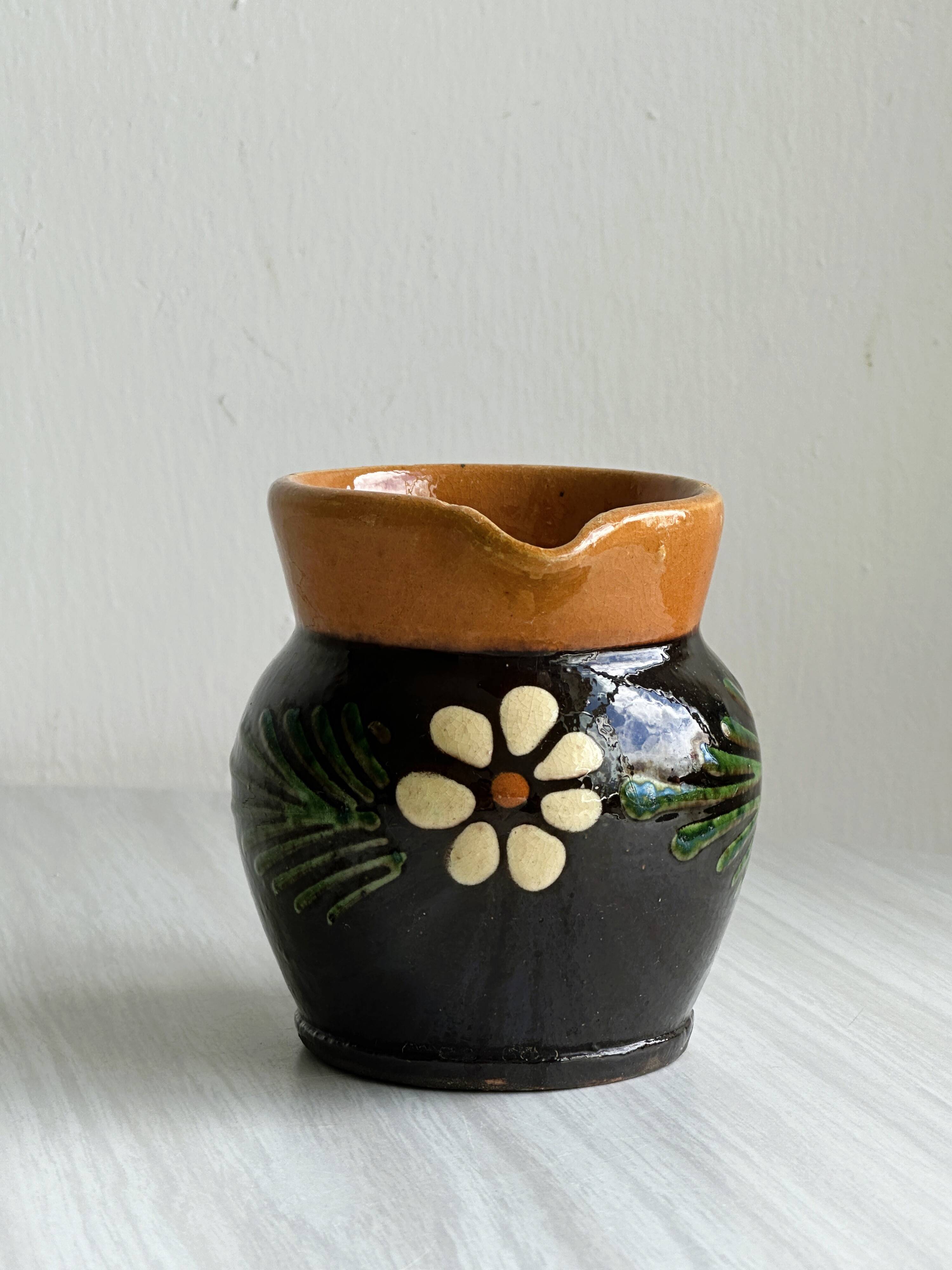 Petit pichet Alsacien en céramique noire et marron, décoré de motifs floraux peints à la main.