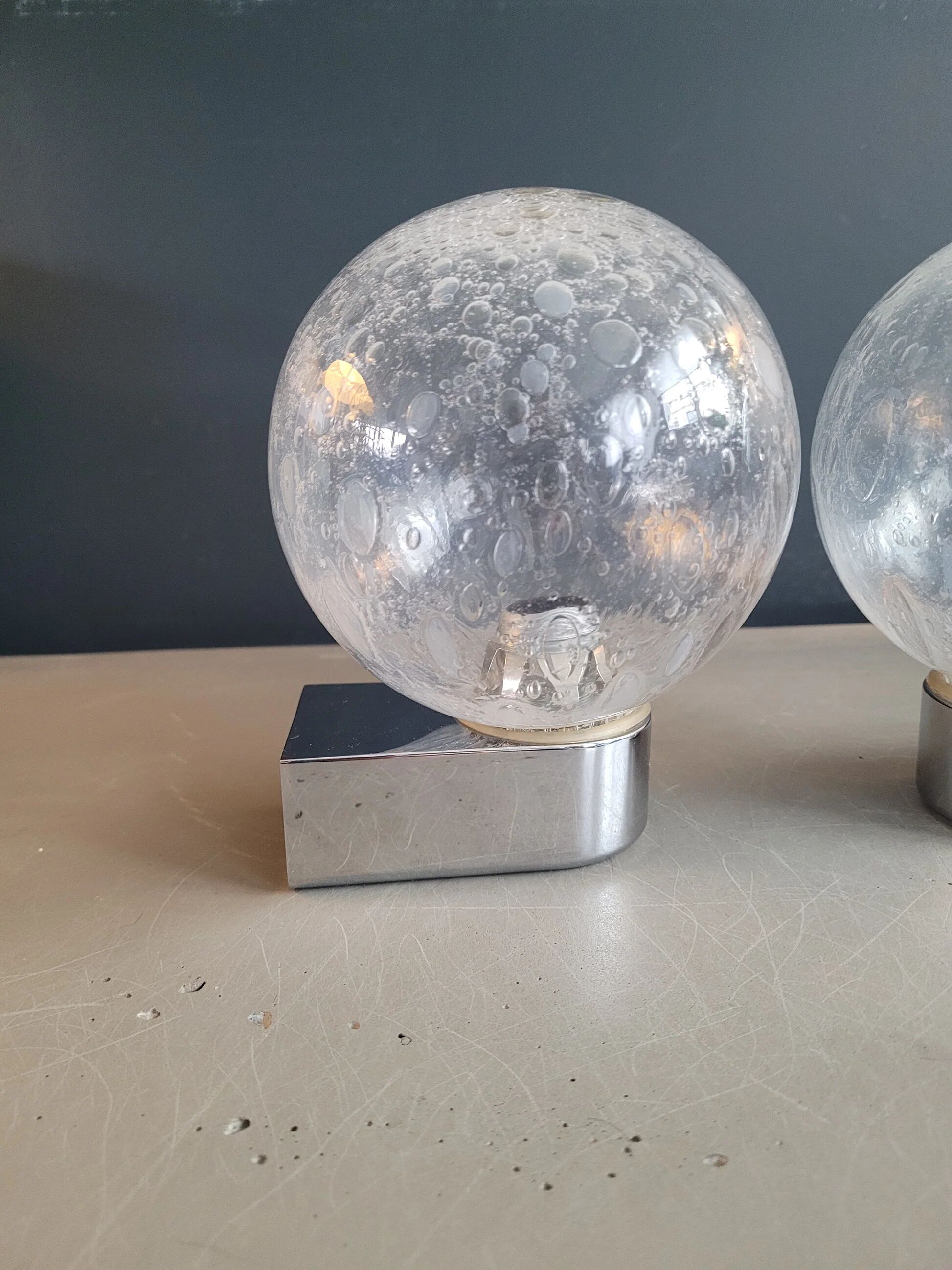 Pair of vintage wall lights in chrome metal with bubbled glass globes.