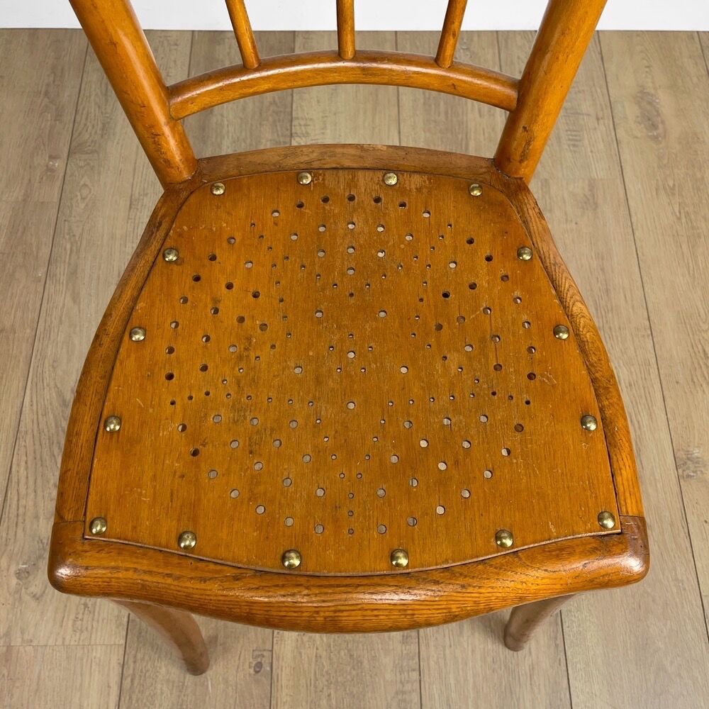 Pair of curved wood bistro chairs and studded and perforated seat