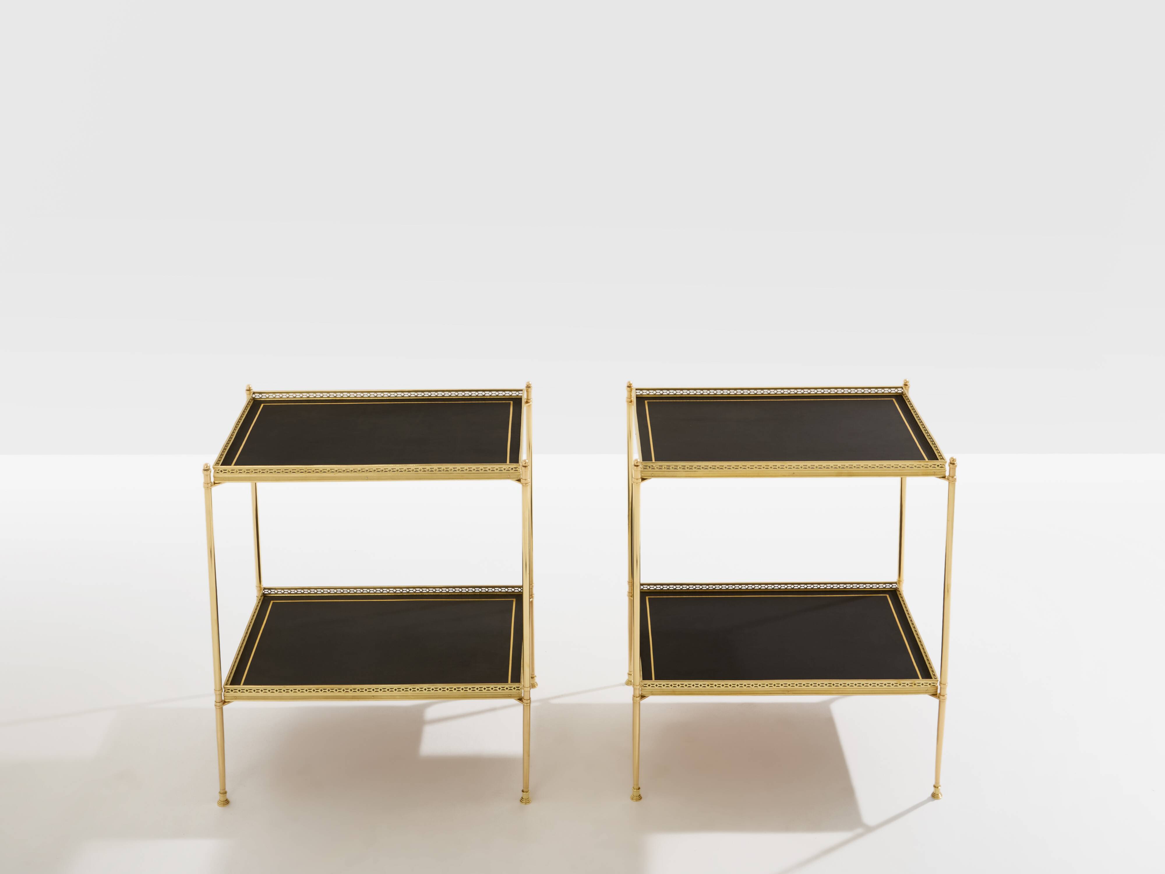 Pair of neoclassical side tables in brass and black leather by Maison Jansen, 1960.