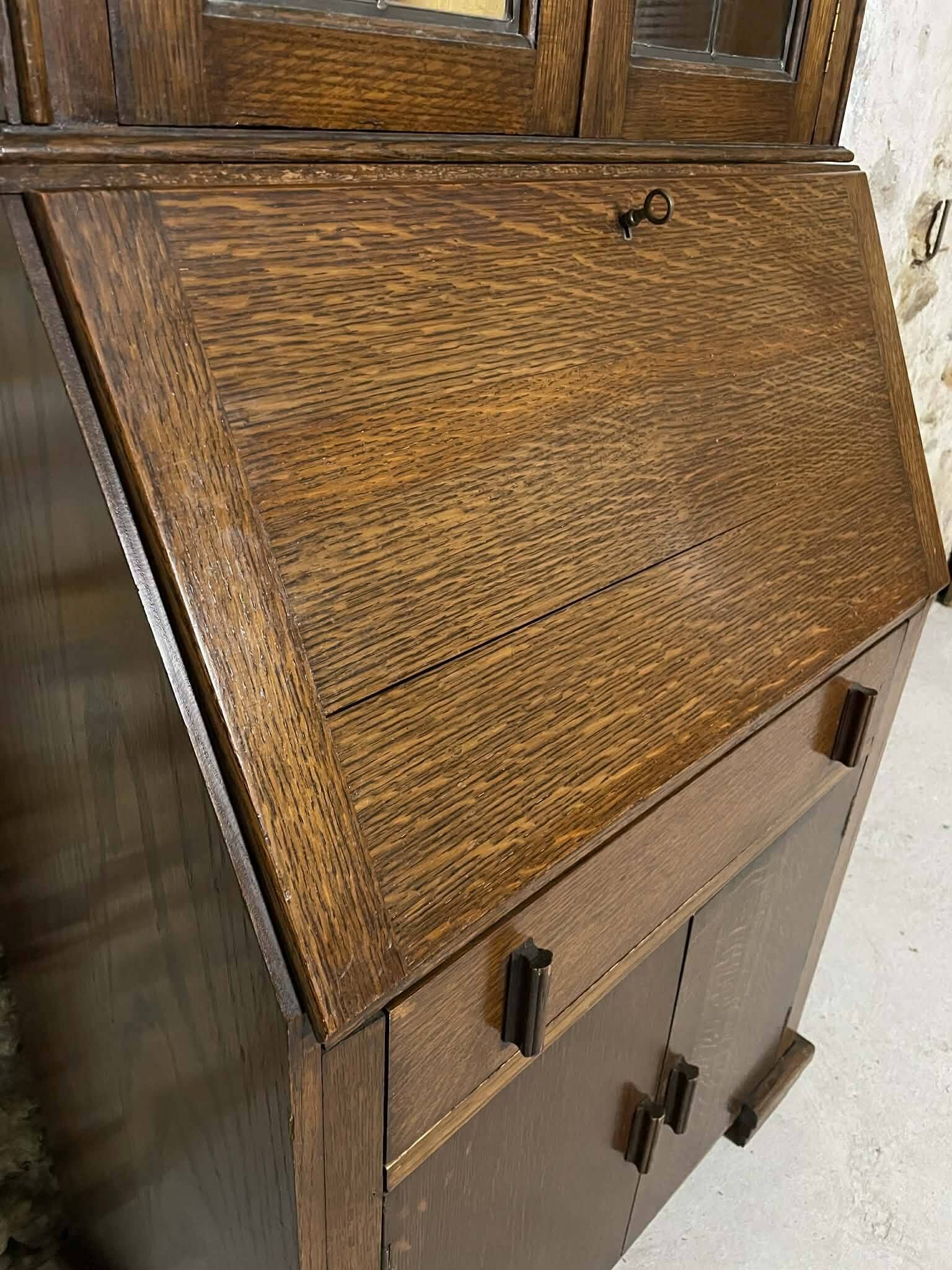 Oak display secretary cabinet with drop-down front, two sections.