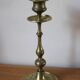 Brass candle holder with flowers and round shape.