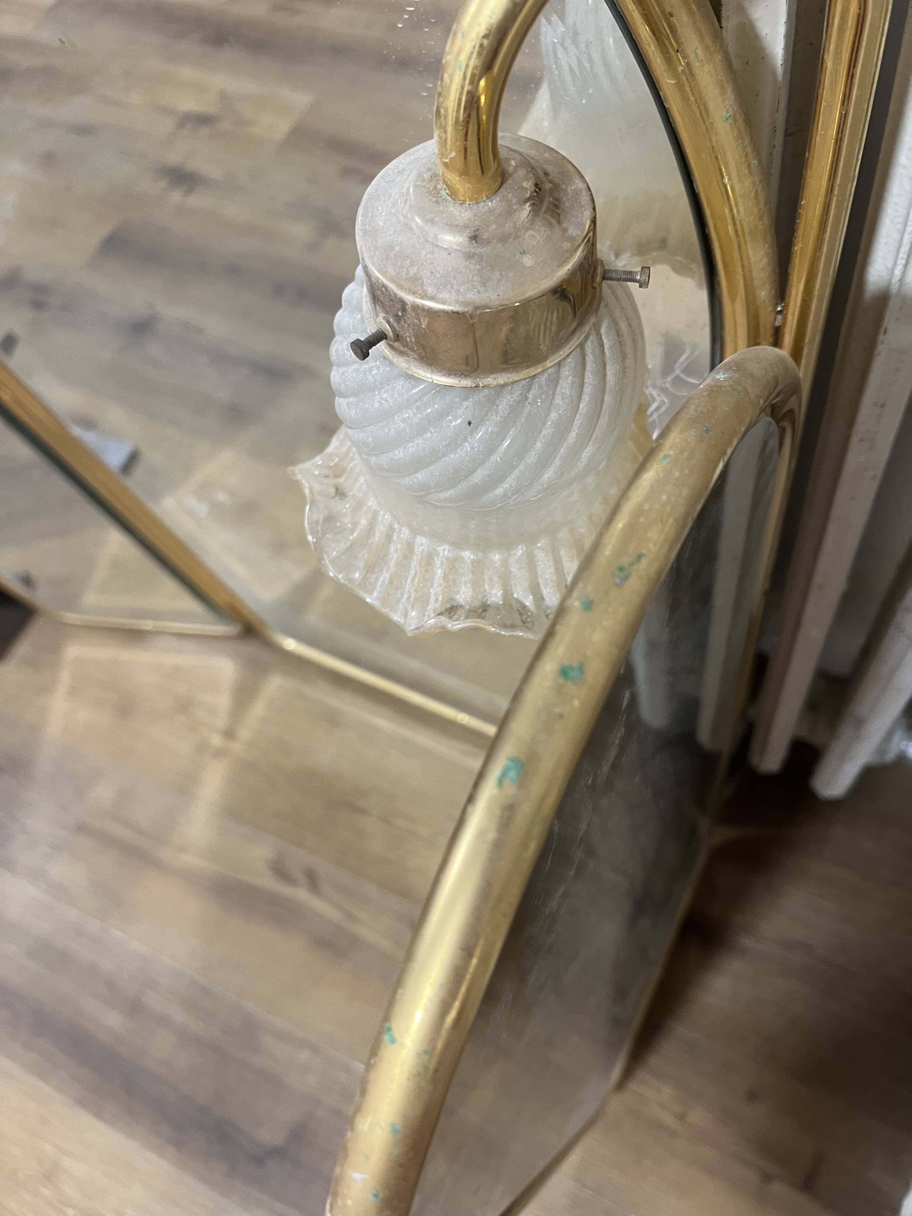 Vintage triptych mirror in brass with wall lights.