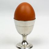 Four silver-plated Christofle egg cups with fluted sides.
