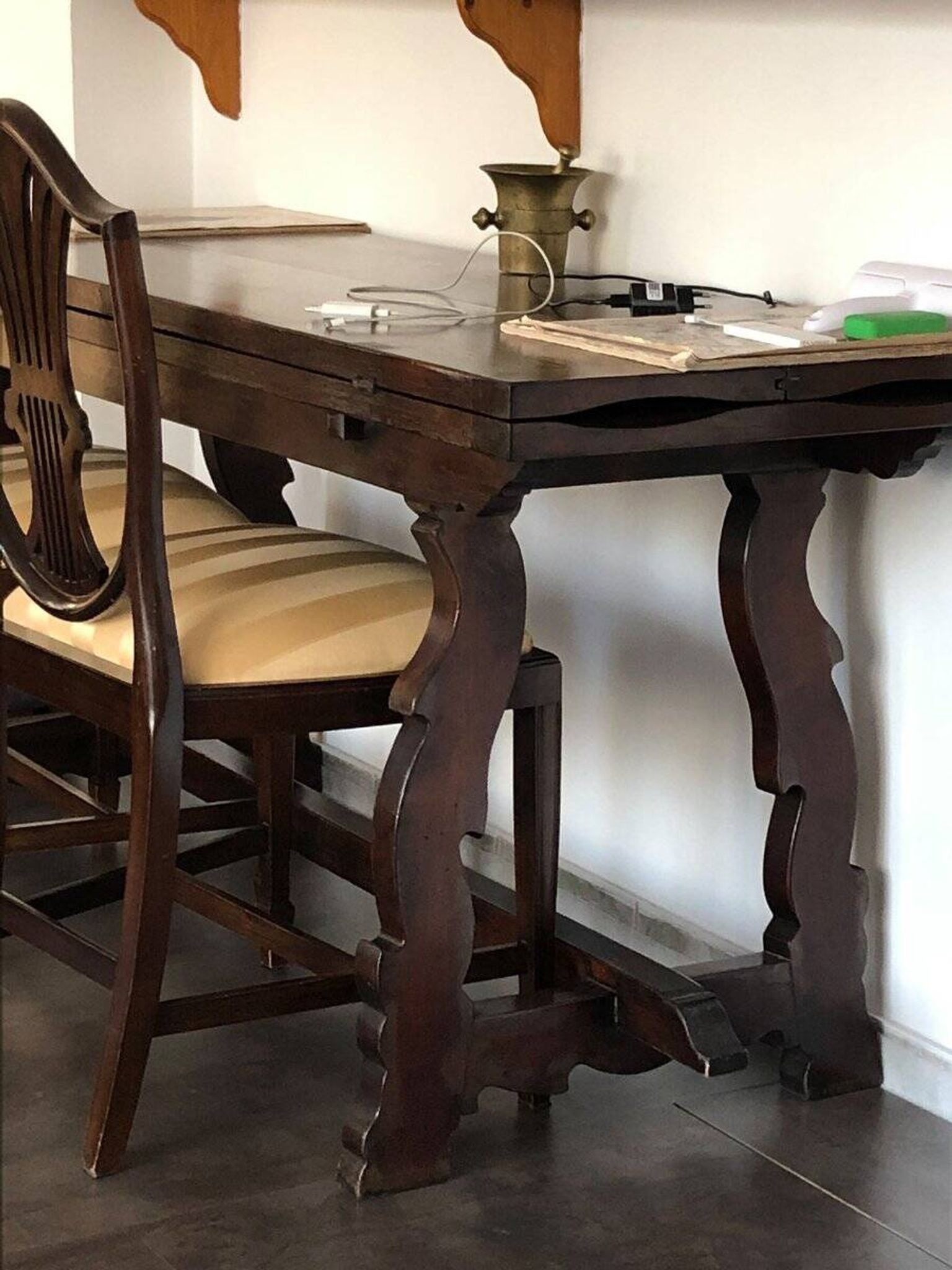 19th-century brown walnut dining table with sculpted trestle legs.