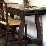 19th-century brown walnut dining table with sculpted trestle legs.