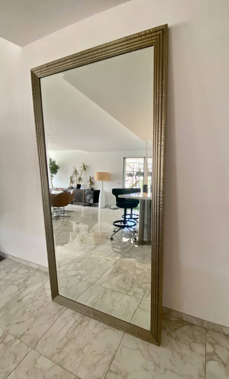 Textured embossed metal wall mirror with bevelled mirror.