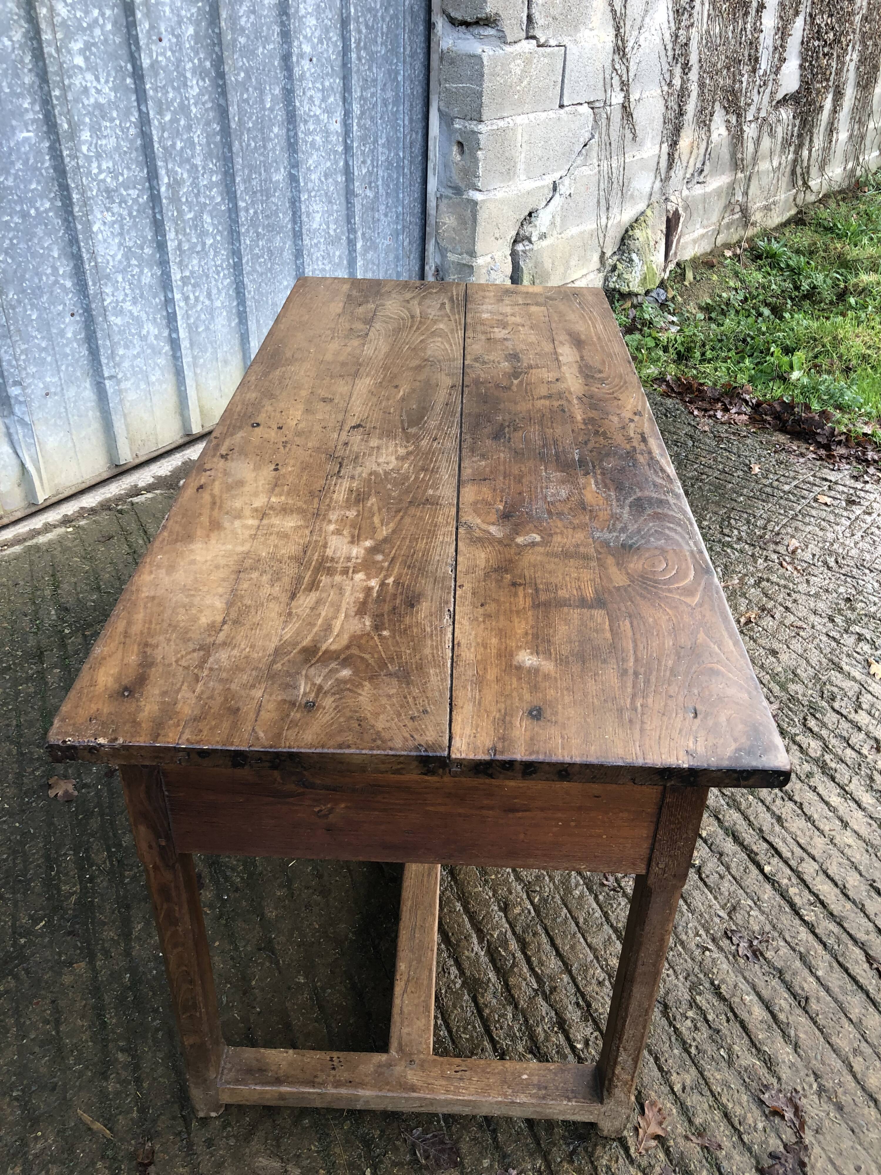 Old chestnut table with 3 front drawers and a cat bar.