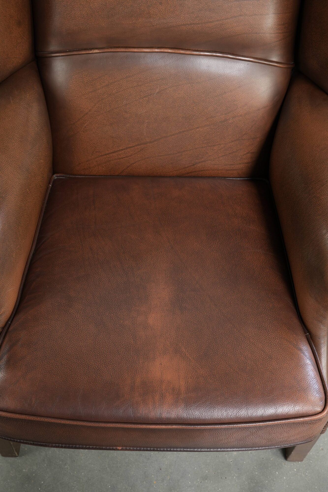 Cowhide wingback armchair in English style finished with decorative nails