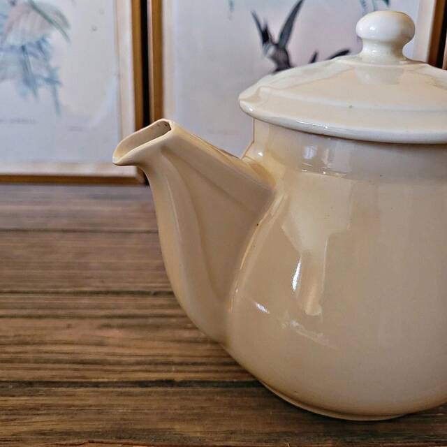 Vintage round ceramic teapot in cream colour, art deco style.