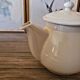 Vintage round ceramic teapot in cream colour, art deco style.