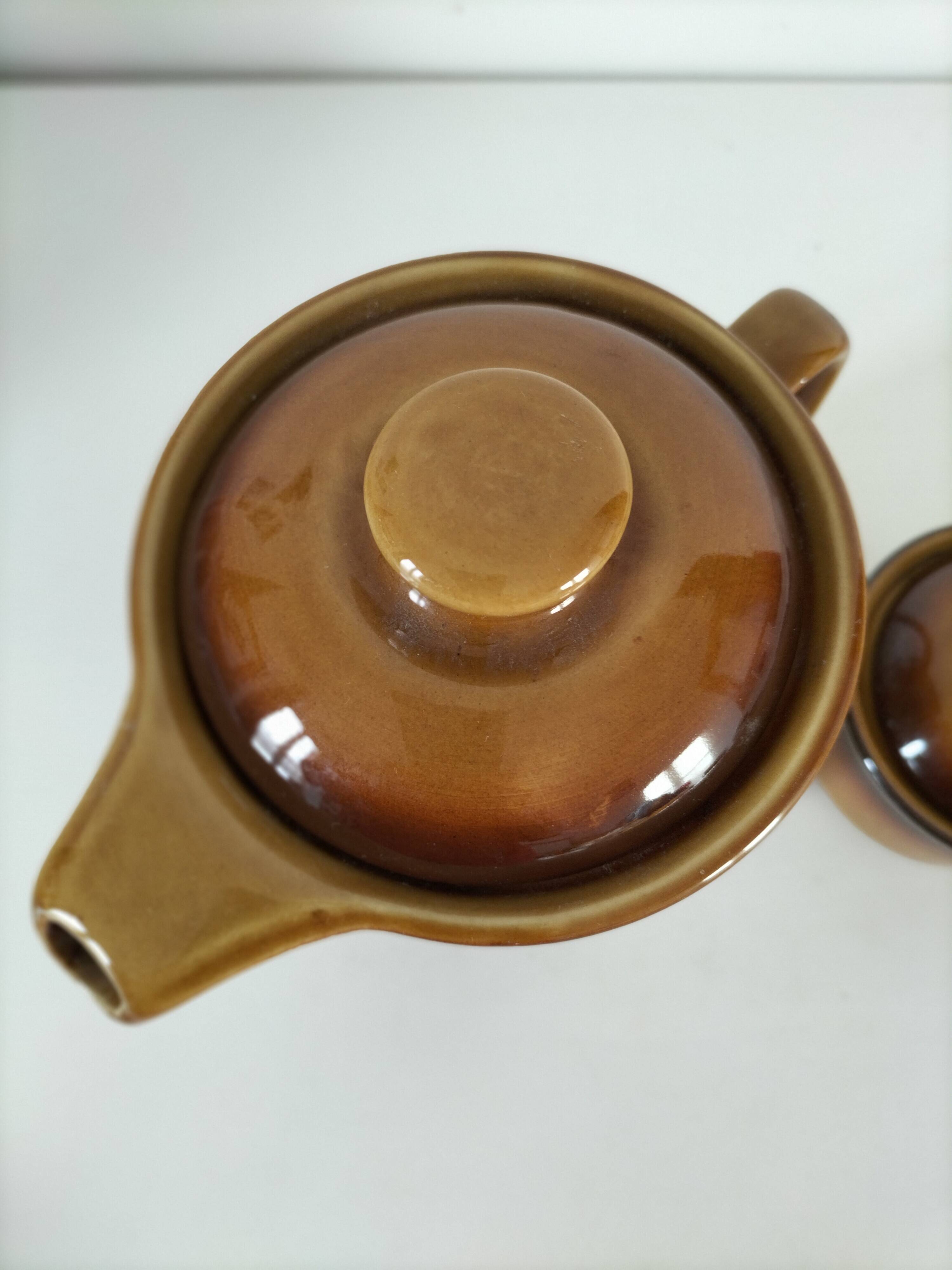 Coffee pot and sugar bowl in glazed stoneware, deep brown glazes.