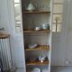 Shallow depth bookcase re-enchanted in pearl gray, wooden shelves.