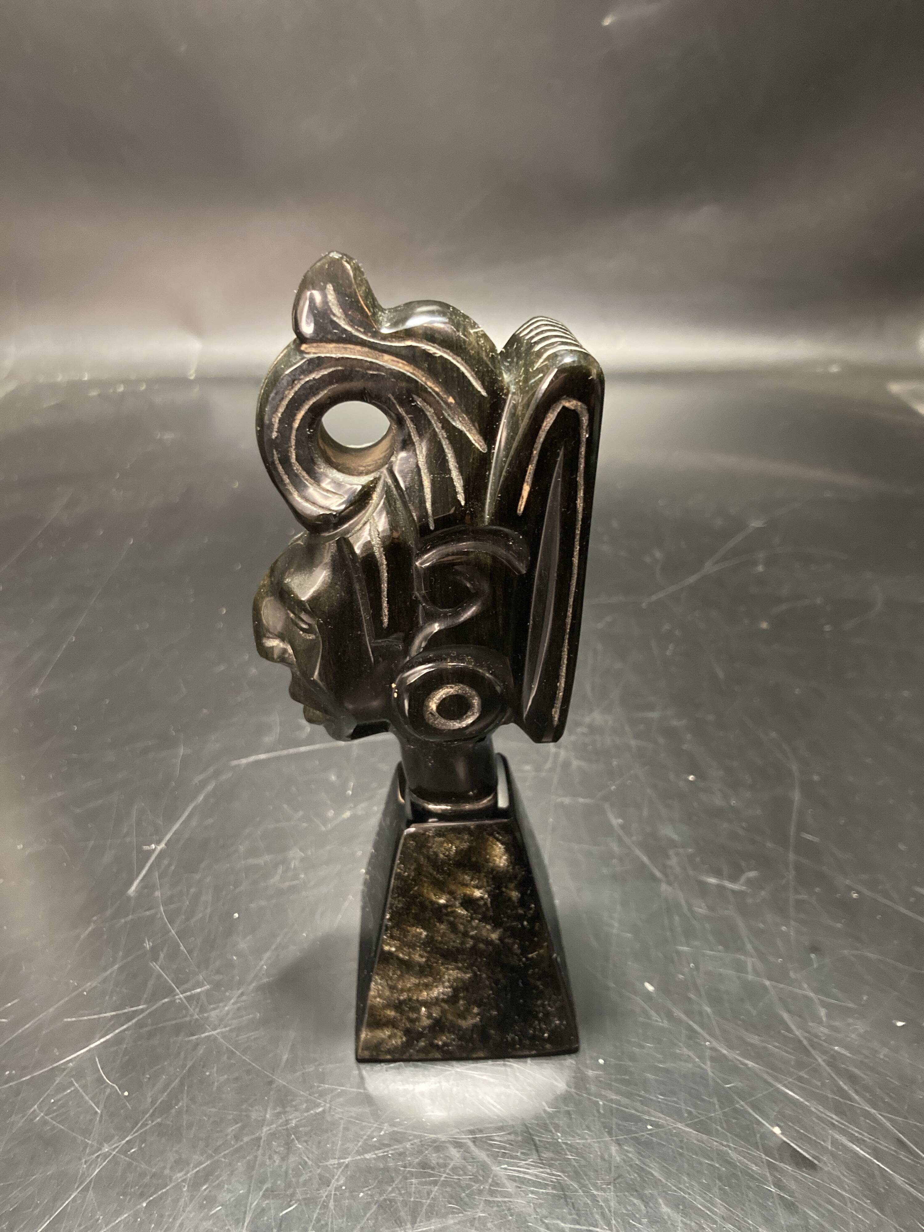 Ceramic sculpture representing a woman's face placed on a black base