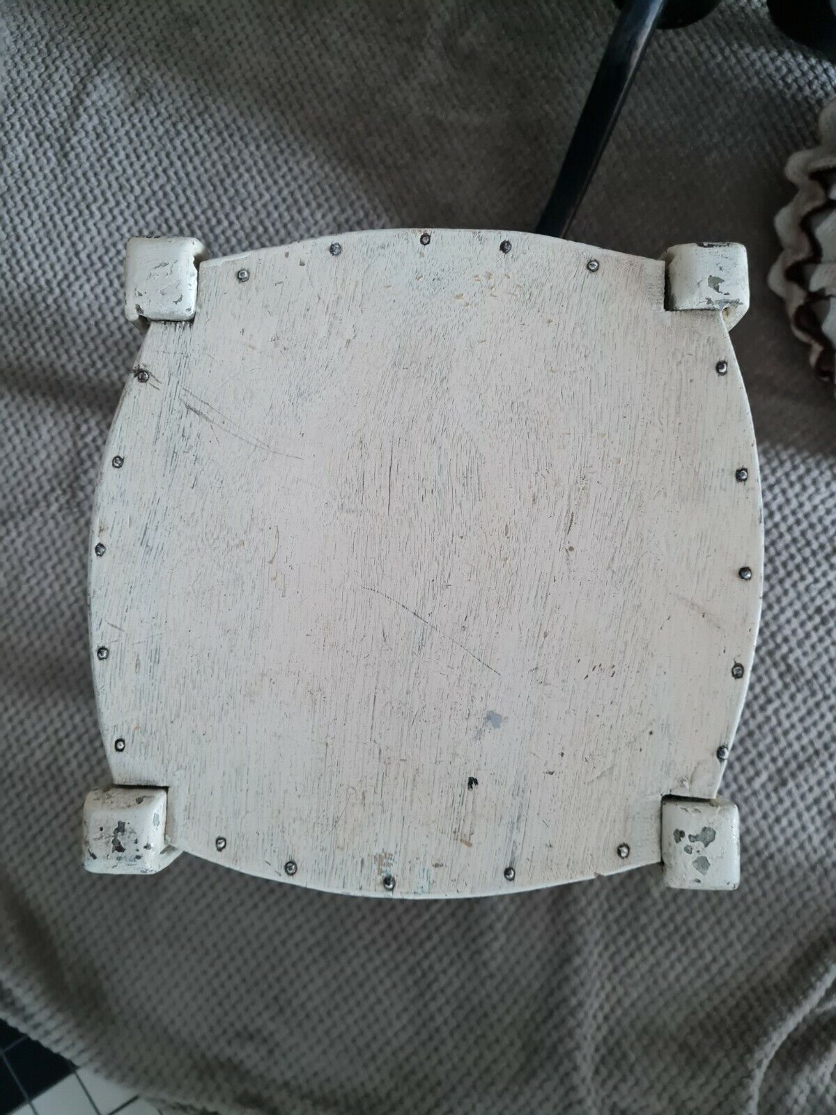 Vintage wooden stool with white peeling paint