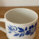 Set of 2 antique earthenware cups with blue floral pattern.