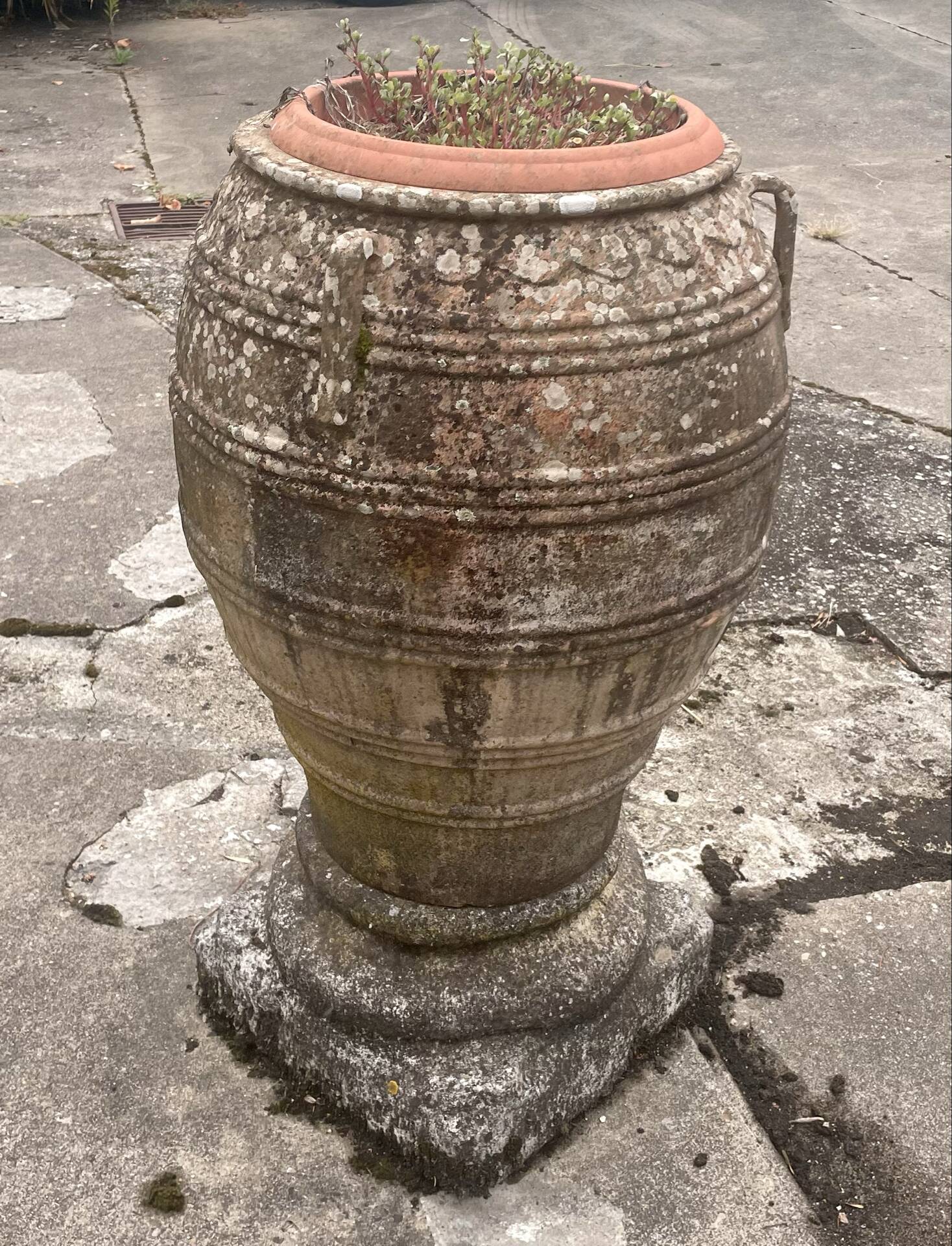 Large Cretan jar in terracotta with three handles on a stone base.