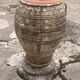 Large Cretan jar in terracotta with three handles on a stone base.