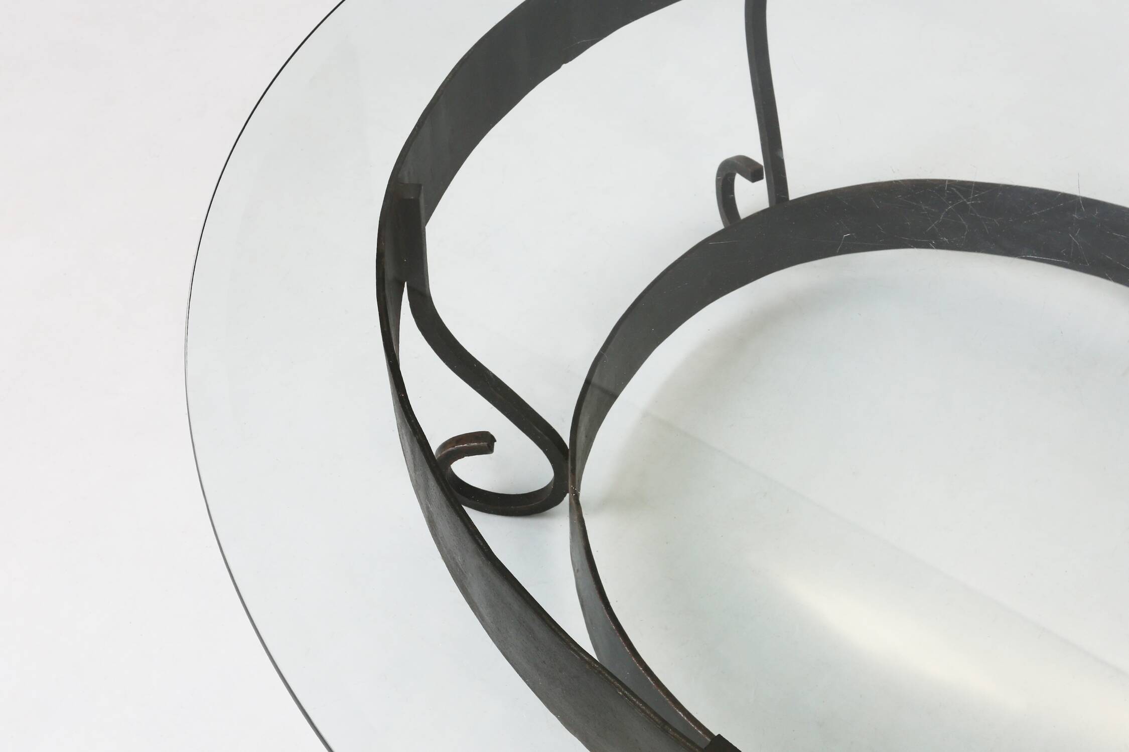 Rustic round coffee table with wrought iron base and glass top, France, 1930s