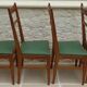 6 modern chairs with banded backs and green faux leather seats.
