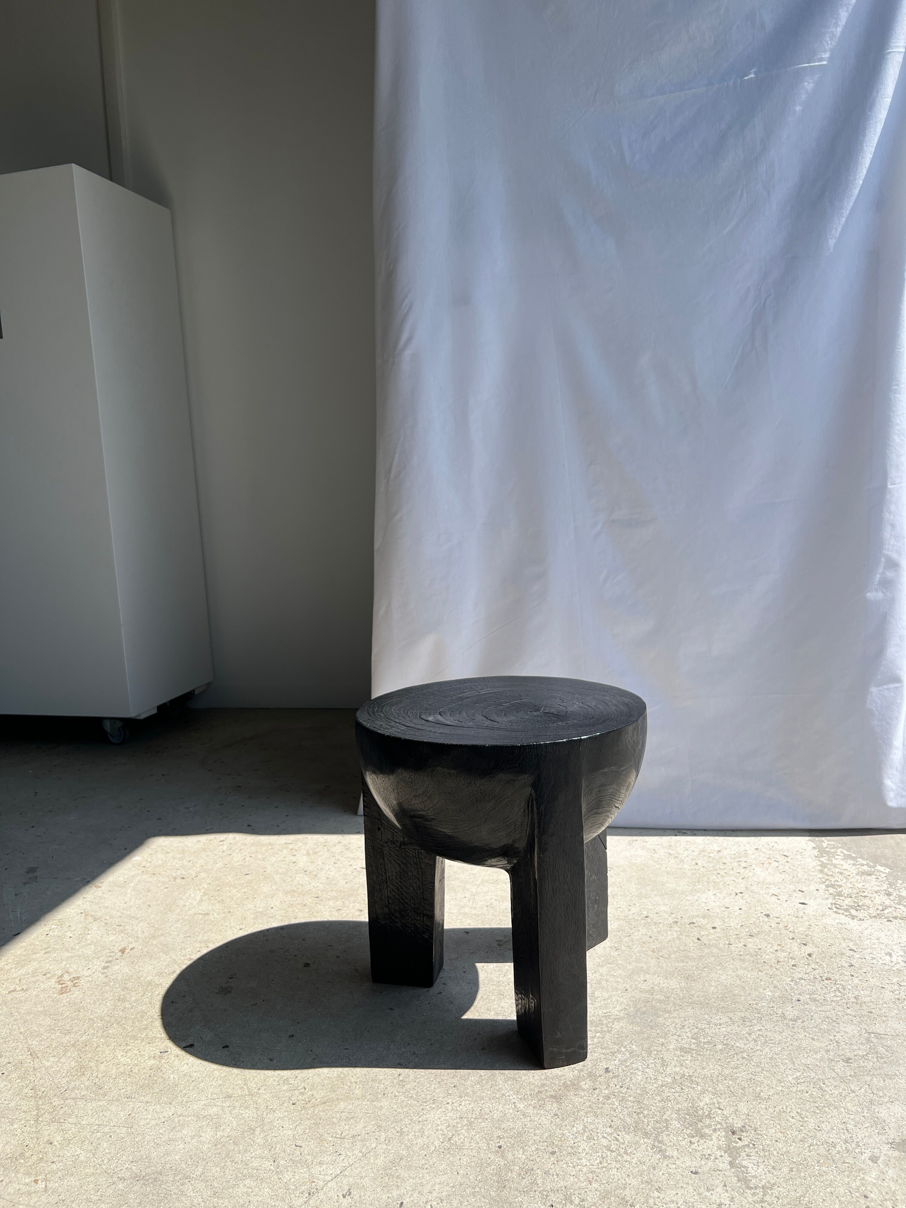 Black mango wood tripod side table with a semi-spherical top, height: 45 cm, diameter: 44 cm.