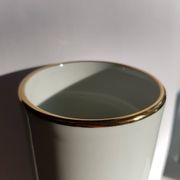 White porcelain vase from Limoges with blue decoration and gold rim.