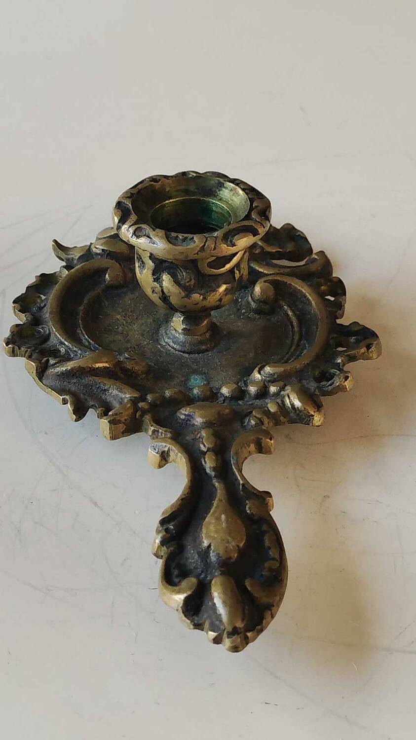 Antique Baroque/Rocaille style hand candle holder. In bronze with an old gold patina.