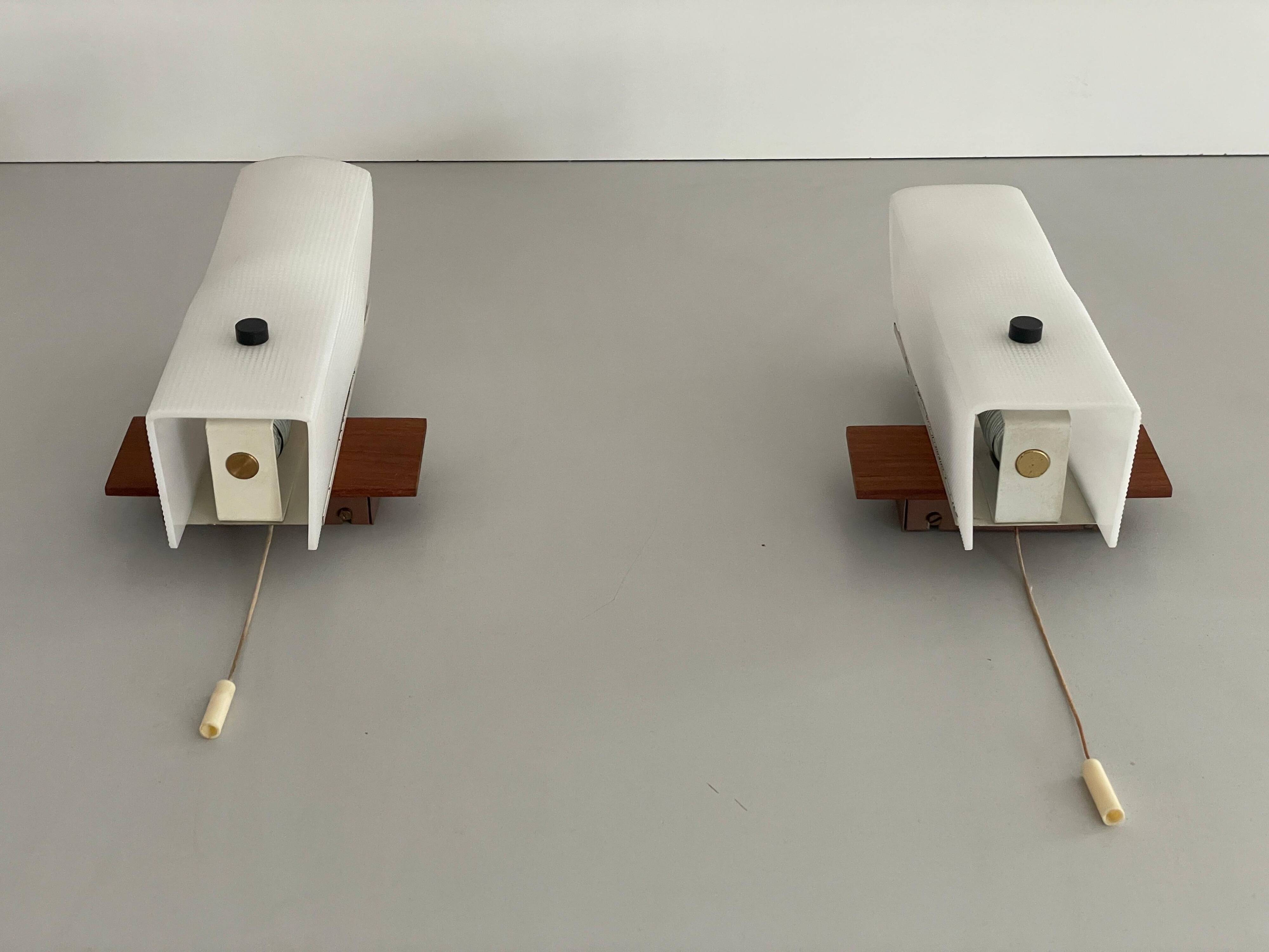 Mid-century wall lights in white plexiglass with a wooden base, 1960s, Germany.