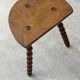 Antique solid wood stool with turned legs.