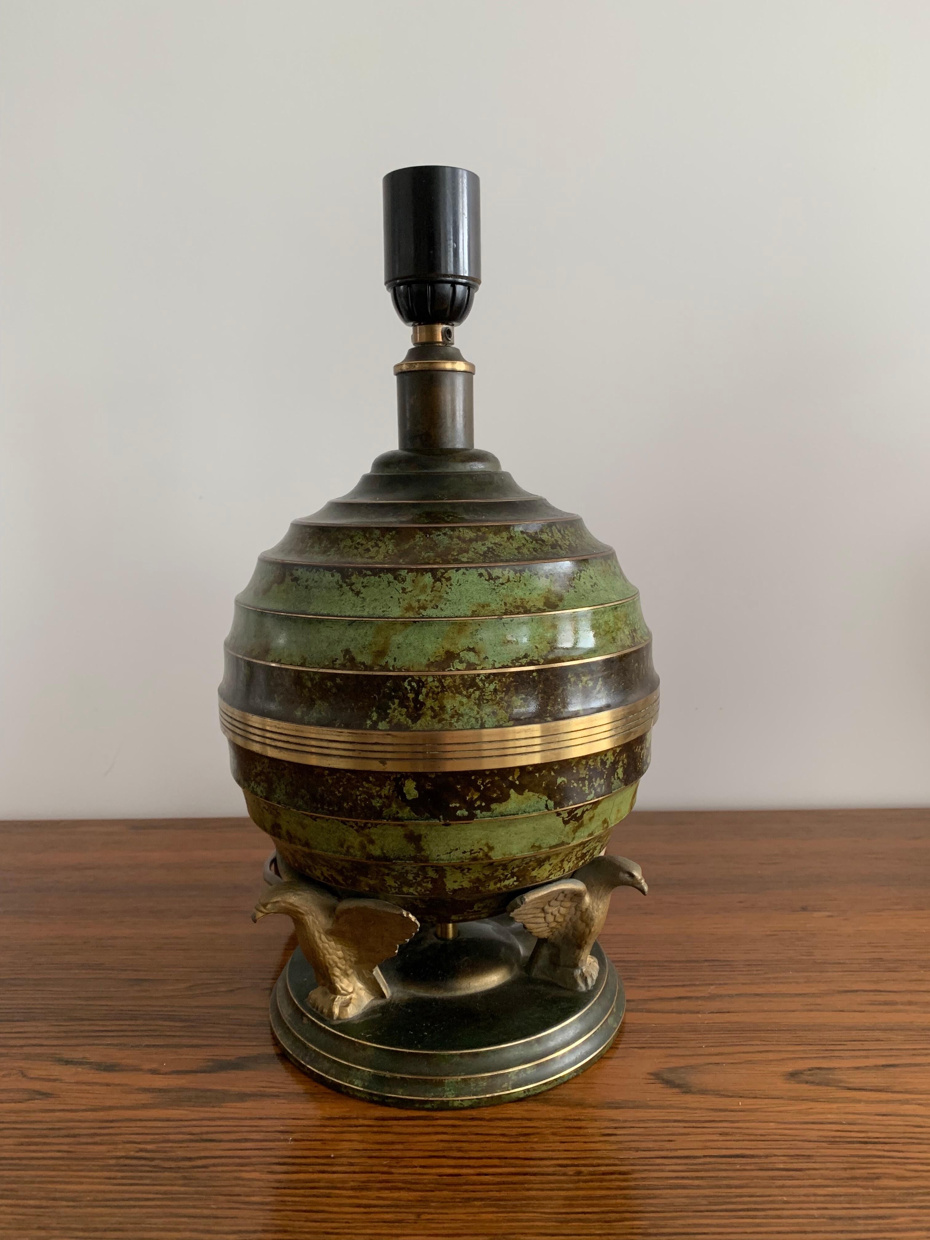 Art Deco table lamp in patinated bronze with eagles holding a globe, France 1940.
