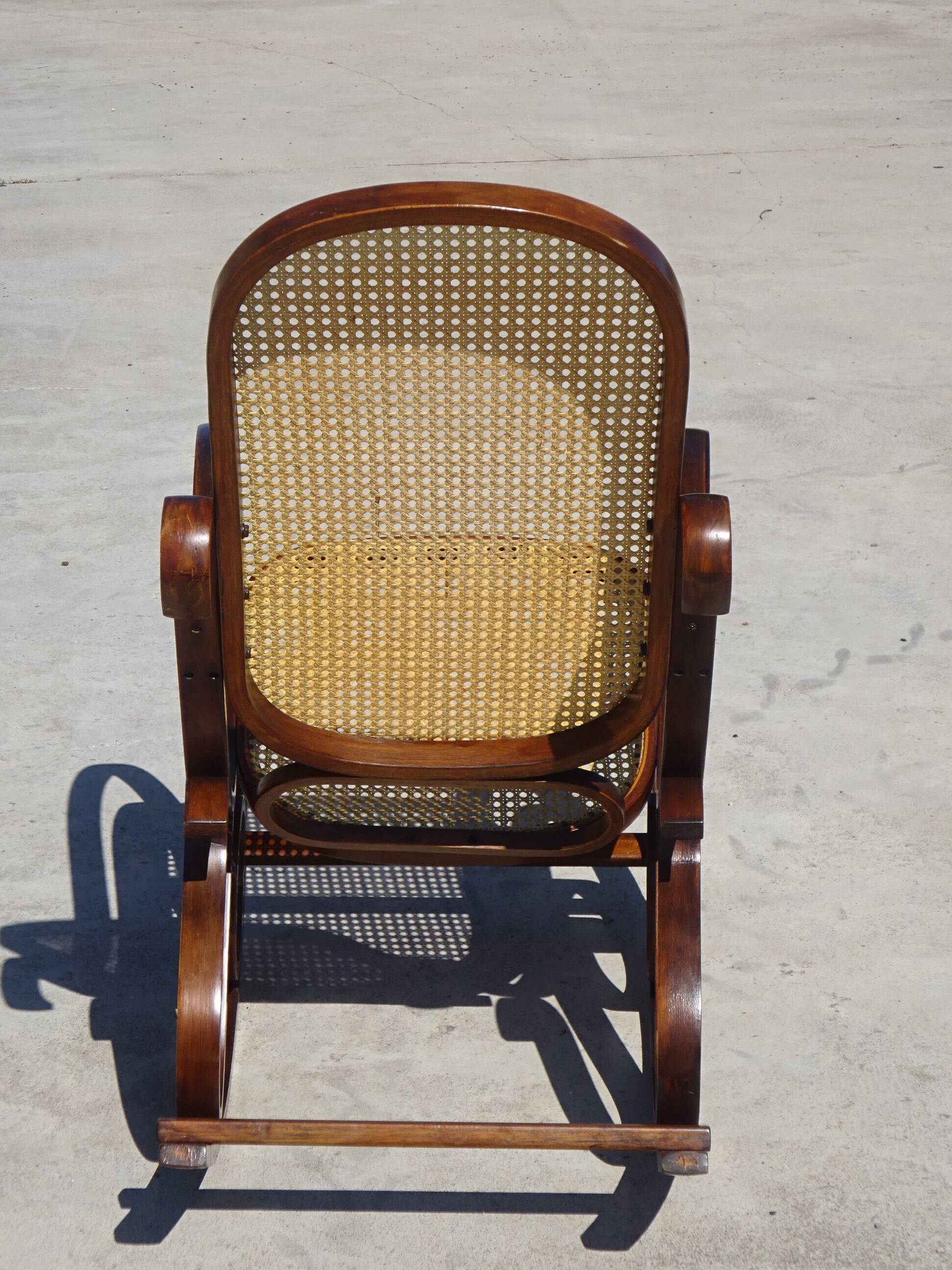 Vintage wooden rocking chair with caning