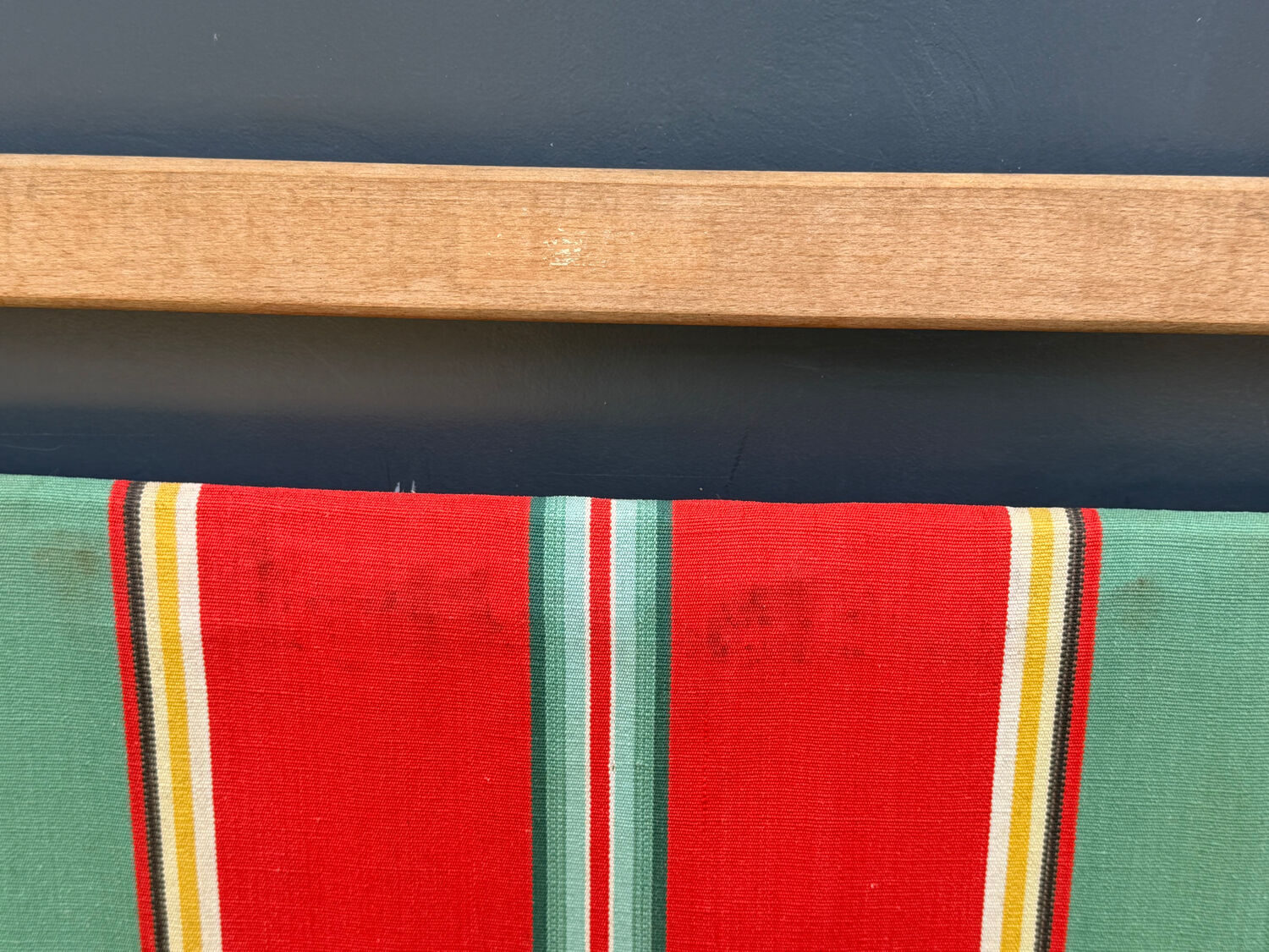 Vintage deck chair with striped green and red fabric, original patina.