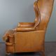Old wingback armchair made of sheep leather in a correct condition