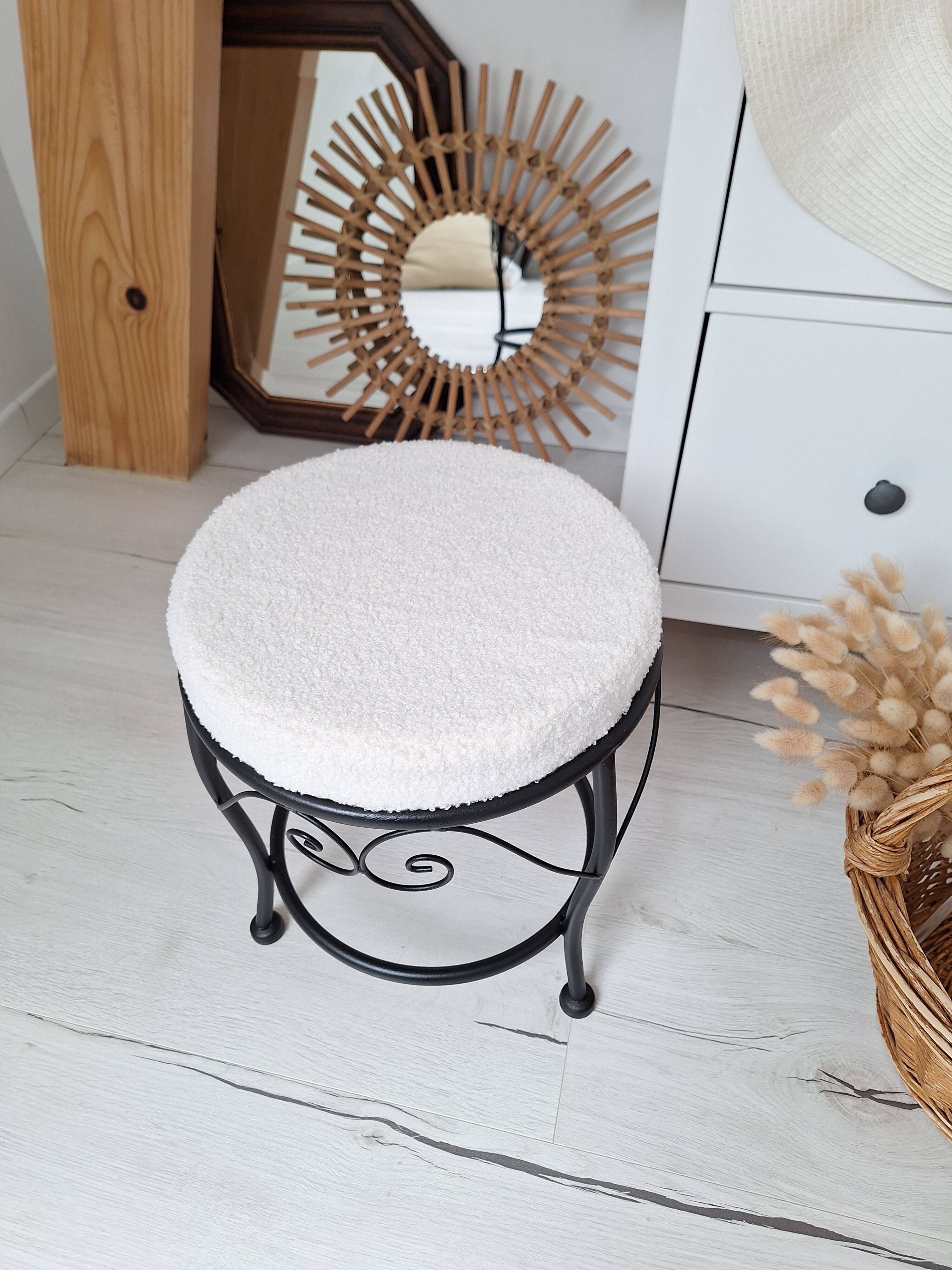 Black iron stool/pouf with its boucle fabric cushion.