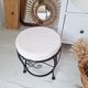 Black iron stool/pouf with its boucle fabric cushion.