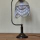 Retro brass lamp with a glass shade and bead fringes.