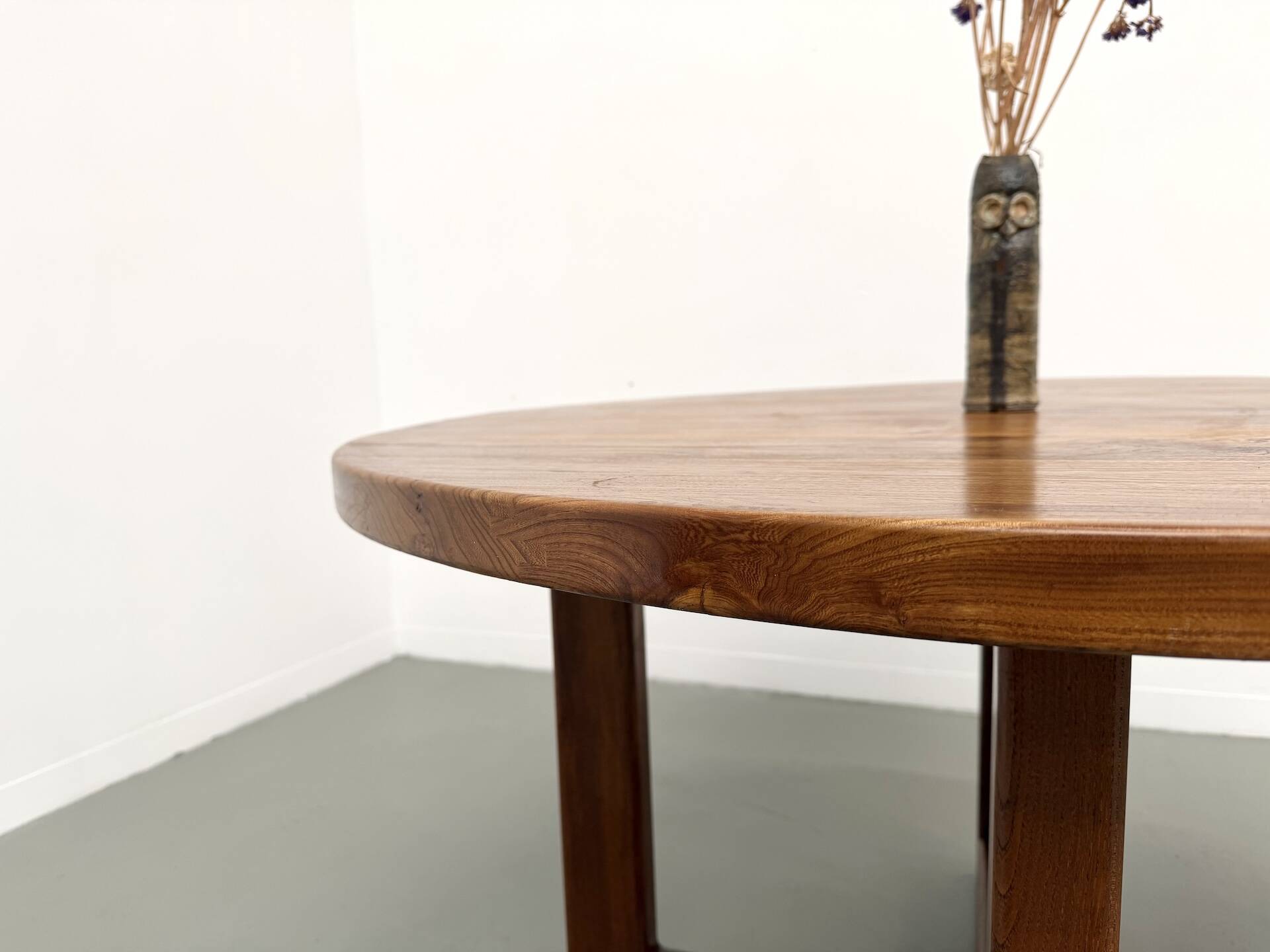 Modernist round table in solid elm, crossed legs.