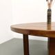 Modernist round table in solid elm, crossed legs.