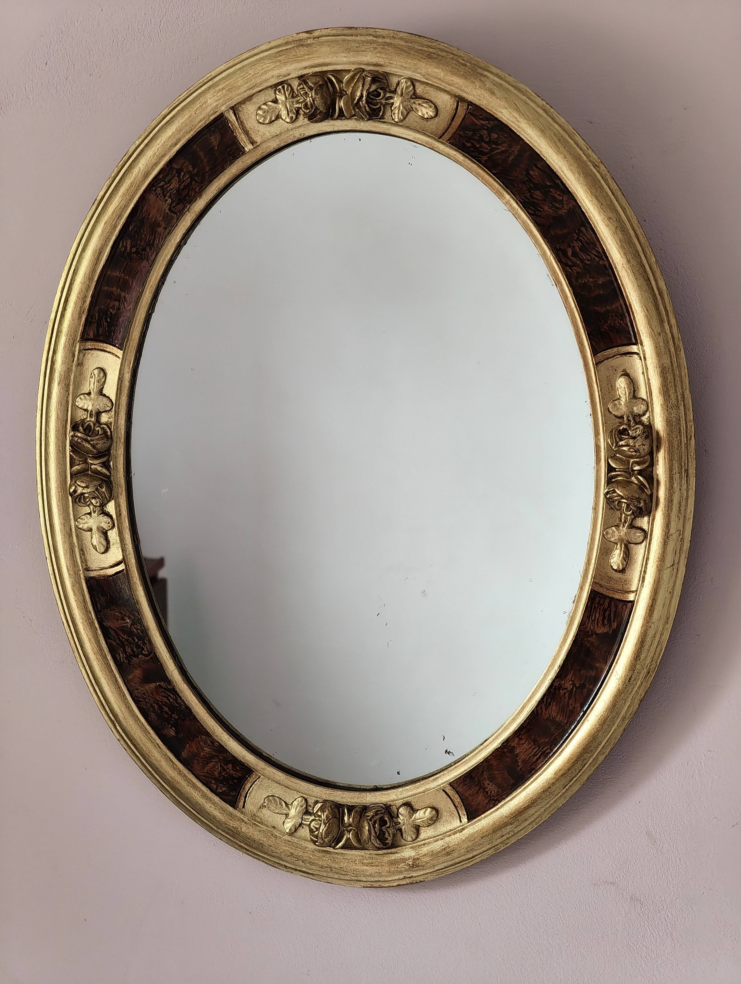 Antique medallion mirror with a gilded and relief-carved frame.
